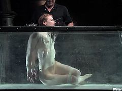Water Bondage scene with redhead in fish tank