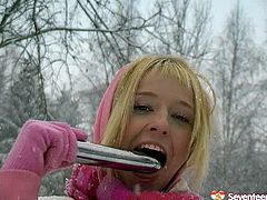 This young blond idiot doesn't think about consequences at all. She heads outdoors in snowy weather wearing a raunchy mini skirt, which she pulls up to poke her vagina with a dildo.