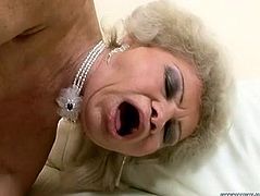 Trashy granny wearing white nylon stockings and red corset bends over the couch lifting her ass up in the air. Perverted dude butt plugs her with sex machine. He also pins her vaginal folds causing her pain and joy at a time. Nasty granny cums getting brutally fucked in her butt hole.