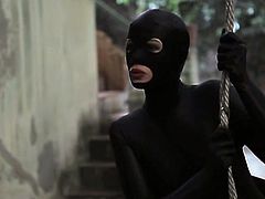 This woman dressed in a catsuit is intruding in a house. She ties a down up, engulfs his cock and rides it.