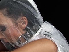 Kinky girl in bride's dress is hogtied in standing position wearing mouth gag. She gets whipped hard in the beginning of the session. Then her pussy hole is fingered intensively.