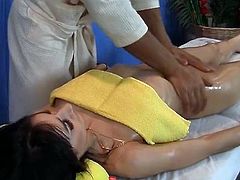 Leggy oiled brunette gets her sexy ass fucked on the massage table