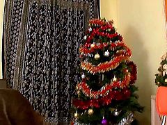 Skinny long haired brunette Rachelle with small titties and tight ass takes off clothes and fingers hairy twat to warm orgasmic feeling by the Christmas tree in close up.