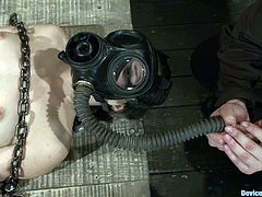 This brunette siren gets chained and suspended with a ball gag in her mouth. Then her master puts a gas mask on her face and controls her breath!