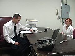 Naughty red haired secretary is about to give her boss steamy blowjob. She unbuttons her blouse and he starts to play with he juicy tits.