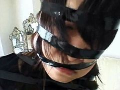 Girl bound by shiny black electric tape