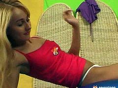 A young blonde girl is kneeling on the studio floor. She removes her miniskirt, revealing her white G-string. She sits down on a large ball, balancing on it. Laying down she pulls her top down and lays with her nipples.