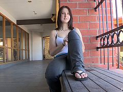 Veronika goes outside after the workout in a gym. She sits down on a bench and pulls pants down. She plays with her pussy and fondles tits.