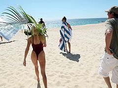 Superb Playboy model poses for the camera on a beach. This hottie also takes off her swimsuit to show her perfect boobs.