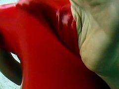 Kinky slut in red latex inserts a huge dildo in her pussy. After she masturbates she pisses