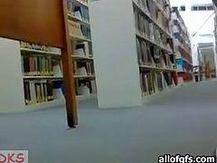 Pretty girl with small tits goes kinky in a public library. She flashes her tits while nobody sees her. She also slides her hand under her skirt. She fondles her coochie upskirt.