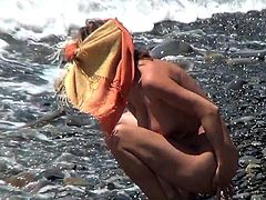 Hidden cam pleases voyeur's desires by spying one nude hottie enjoying the sun at the beach