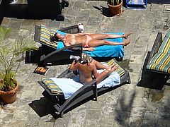 two hot girls poolside in waikiki taking their tops off