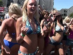 Gorgeous ladies with natural tits and colorful attires dancing passionately in a bikini party outdoor while displaying their hot ass