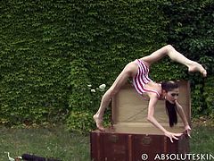 This beautiful brunette comes out of a box positioned outdoors. She is so tiny and skinny that she can fit in that box without a problem. She is also very flexible.