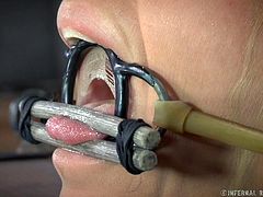Blonde slave Simone has been locked in the shackles by her master. She has her nipples clamps and pantyhose put on her head. The master puts clamps on the slaves lips and cheeks and stretches open her mouth hole so her tongue can be clamped down.