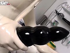 Fiona puts on a very kinky latex and lets her slave fuck her with a huge dildo.