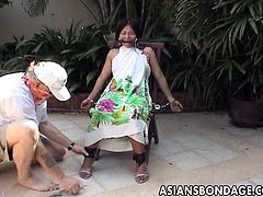 A horny angry guy has been waiting, that a long-haired Asian slut will come out from the building. The helpless lady has to obey and sit on a chair, while her hands and legs are put in shackles. Another kinky accessory, a mouth gag, is required, to stop her screaming. Wanna see what's under her dress?