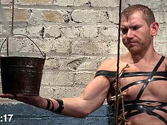 Can this gay slave handle 30 excruciating minutes of water torture? The slave is tied up tightly by his master, in a sex dungeon and has a cloak, put over his head. The master pours cold water on the slave and humiliates him, before tugging him off.