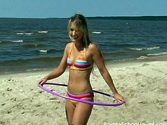 Hula hooping hottie on the beach in a colorful bikini