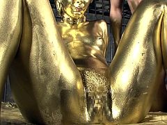 Shiny gold paint covers the Asian girl and her man as they fuck