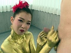 Check out this Asian girl completely painted gold. She dazzles us with her body and cute smile. The hottie winks at the camera and timidly kneels in front of her man's penis to suck him off. The gold queen works the shaft, while using her lips on the head.