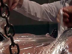 Dean is certainly feeling a little restricted at the moment. He is completely wrapped in plastic wrap, only his nostrils uncovered, so he can breathe. His executor begins the pleasurable torture, using two vibrators to stiffen him up. He unwraps Dean's cock and strokes it, just until he's about to cum.