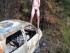 Guy is ejaculating on top of burned car