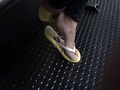 Feet in yellow flip flops play in subway station foot pieds