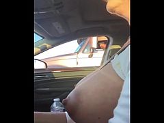 mature woman touches her big boob rolling next to a trucks