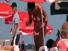 a young lady lying on the beach tried to become a tan and massage her customer and exposed her huge boobs on public.