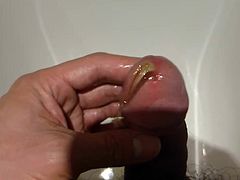 Stroking cock in hotel bath and pissing foreskin pulled back