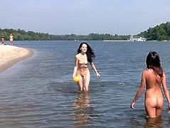 Nude teen friends play around at a public beach