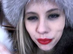 sexy woman in a fur coat shows her slutty mouth